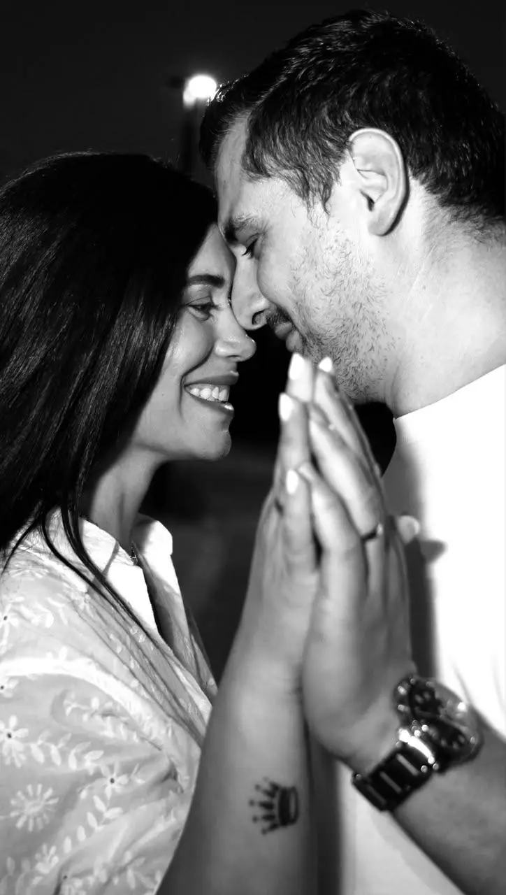 Panayiotis and Teo, foreheads together, hands pressed palm to palm